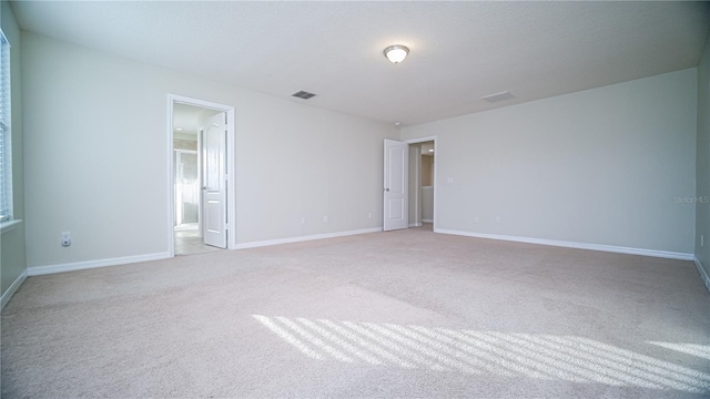 empty room featuring a textured ceiling and light carpet