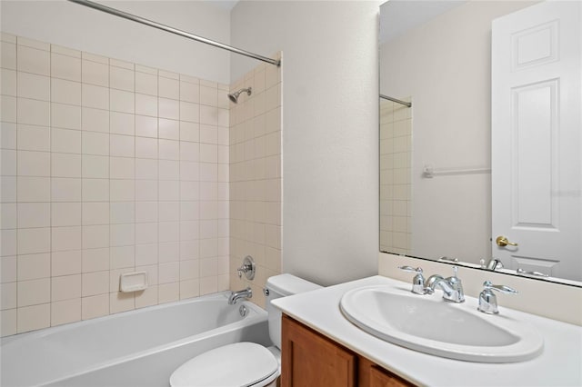 full bathroom featuring toilet, tiled shower / bath, and vanity