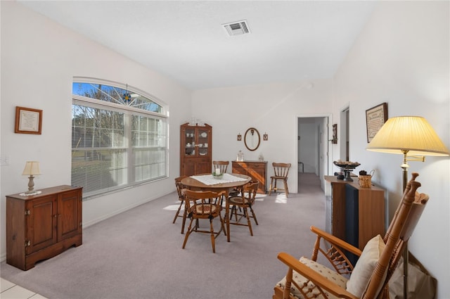 carpeted dining area featuring lofted ceiling