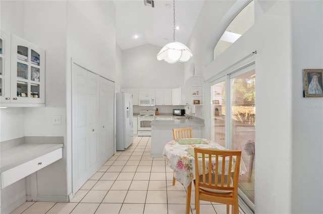 kitchen featuring white appliances, pendant lighting, light tile patterned floors, high vaulted ceiling, and white cabinets