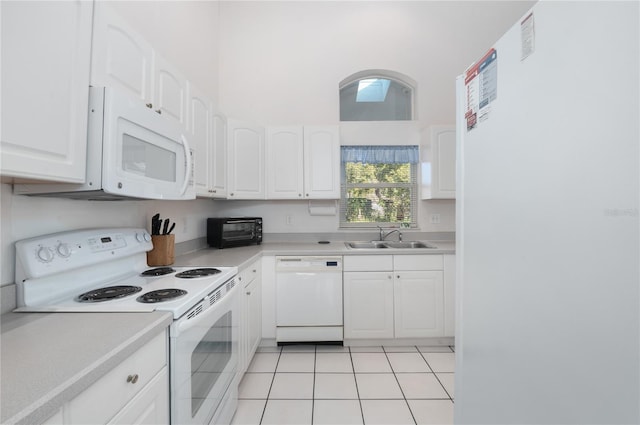 kitchen featuring light tile patterned floors, white appliances, white cabinetry, and sink