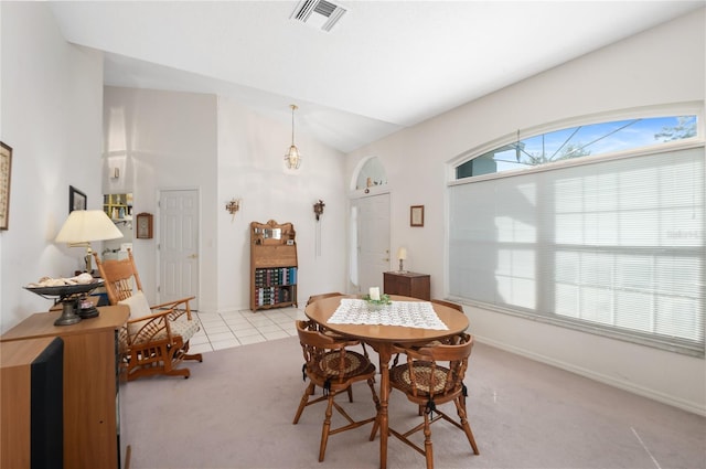 dining space with lofted ceiling and light carpet