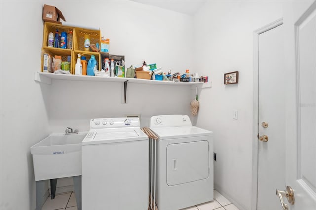 laundry area with washer and clothes dryer, light tile patterned floors, and sink