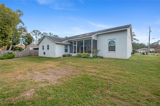 back of property featuring a sunroom and a yard