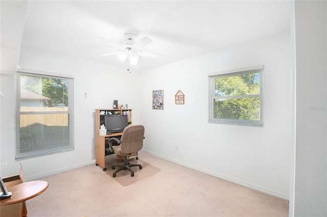 carpeted home office featuring ceiling fan