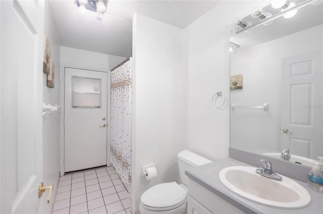 bathroom featuring curtained shower, tile patterned flooring, vanity, and toilet