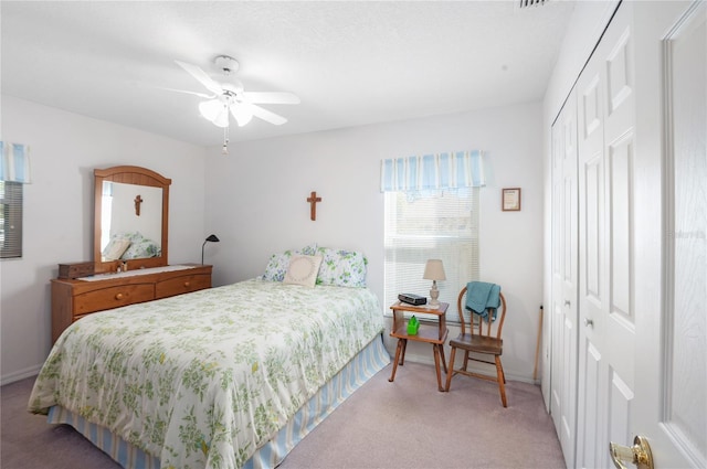 carpeted bedroom with ceiling fan and a closet