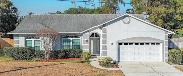 ranch-style home featuring roof with shingles, stucco siding, concrete driveway, an attached garage, and a front yard