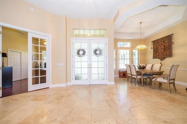 interior space featuring french doors and a raised ceiling