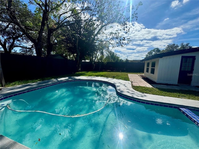 view of swimming pool with a yard