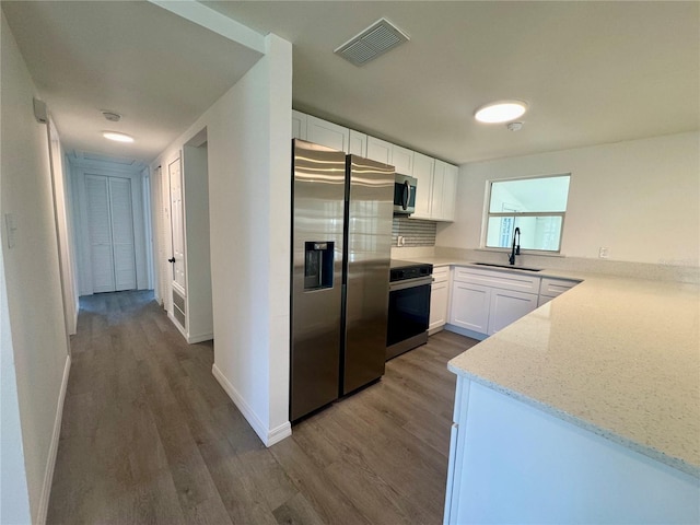 kitchen featuring sink, light hardwood / wood-style floors, light stone counters, white cabinetry, and stainless steel appliances