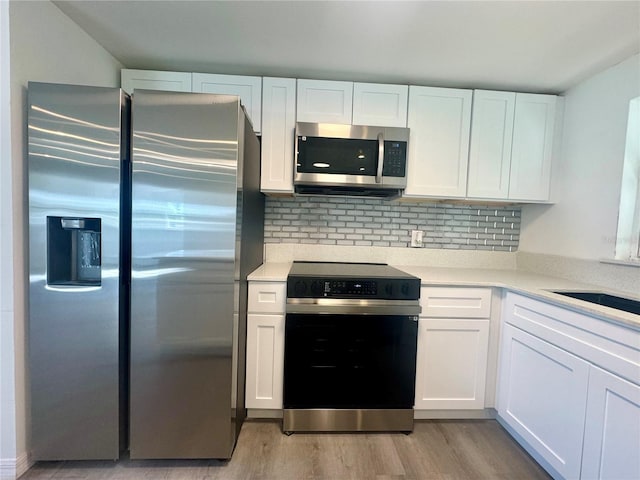 kitchen featuring light wood-type flooring, white cabinetry, appliances with stainless steel finishes, and tasteful backsplash