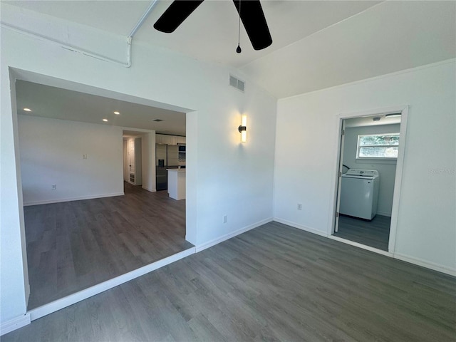 unfurnished room featuring ceiling fan, dark hardwood / wood-style flooring, lofted ceiling, and washer / dryer