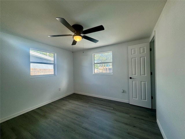 spare room with dark hardwood / wood-style flooring and ceiling fan