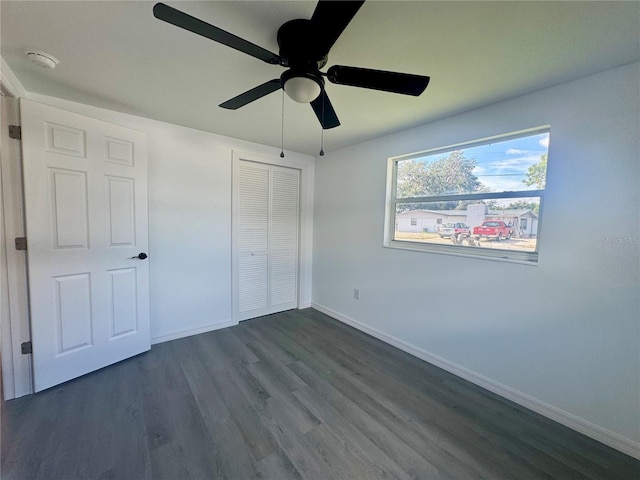 unfurnished bedroom featuring a closet, ceiling fan, and dark wood-type flooring