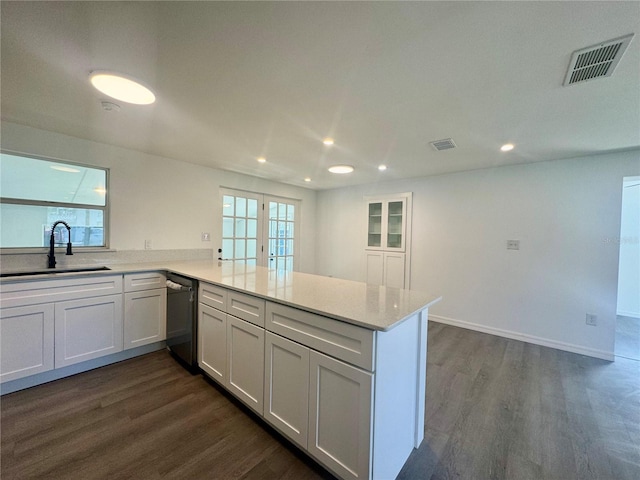 kitchen featuring kitchen peninsula, dark wood-type flooring, sink, white cabinets, and black dishwasher