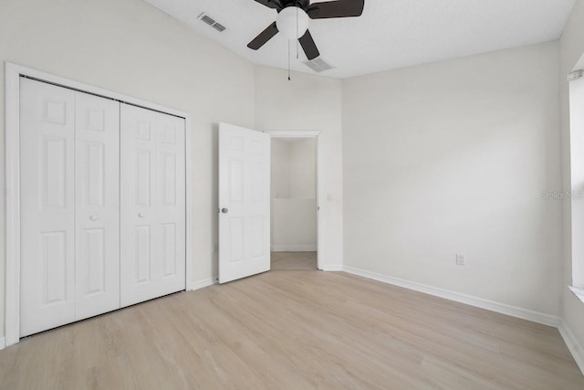 unfurnished bedroom featuring ceiling fan, light hardwood / wood-style floors, and a closet