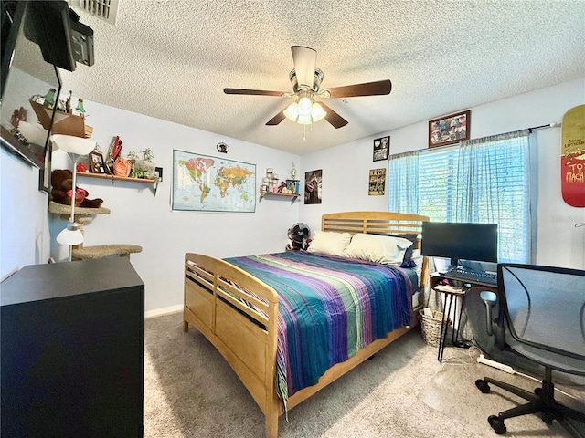 bedroom featuring ceiling fan, carpet floors, and a textured ceiling