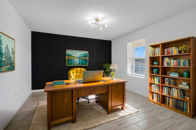 home office featuring an inviting chandelier and light hardwood / wood-style floors