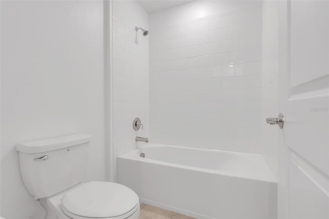 bathroom featuring tiled shower / bath combo and toilet