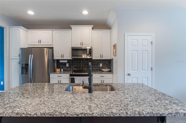 kitchen featuring white cabinets, appliances with stainless steel finishes, a spacious island, and sink