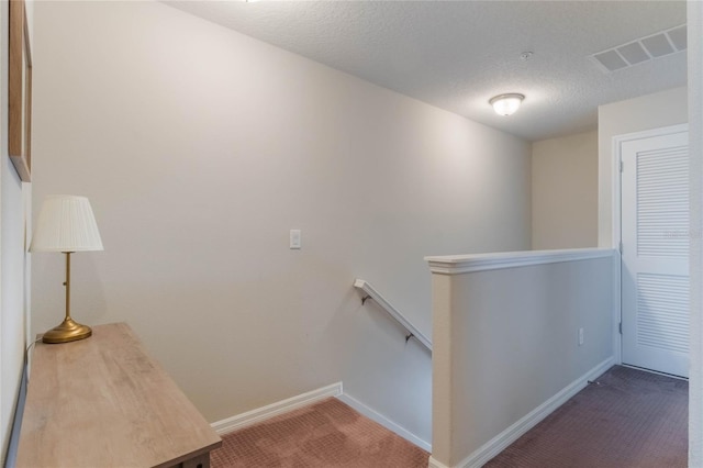 stairs featuring carpet flooring and a textured ceiling