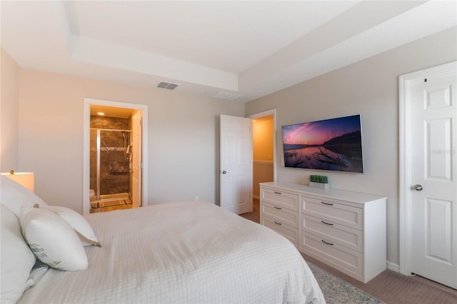 bedroom with a raised ceiling and ensuite bathroom