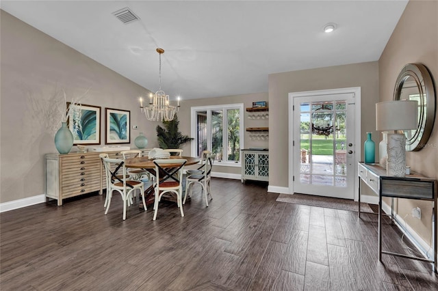 dining room featuring dark hardwood / wood-style floors, vaulted ceiling, and a notable chandelier