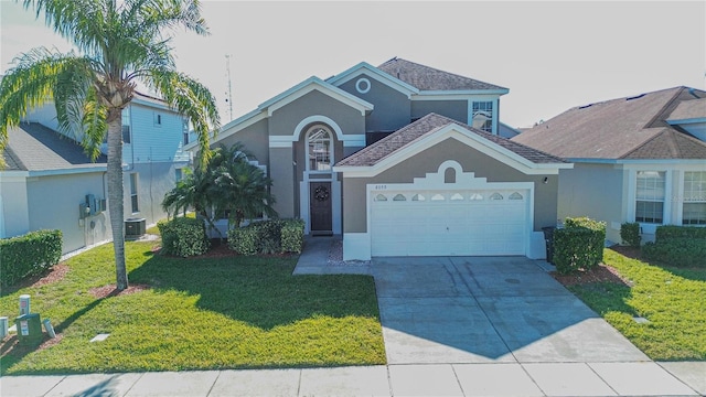 view of front property with central AC, a front yard, and a garage