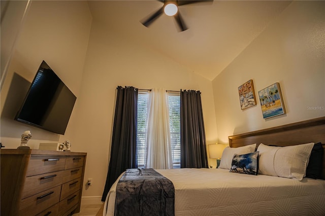 bedroom with hardwood / wood-style flooring, high vaulted ceiling, and ceiling fan