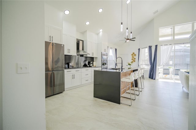 kitchen featuring white cabinetry, sink, an island with sink, a breakfast bar area, and appliances with stainless steel finishes