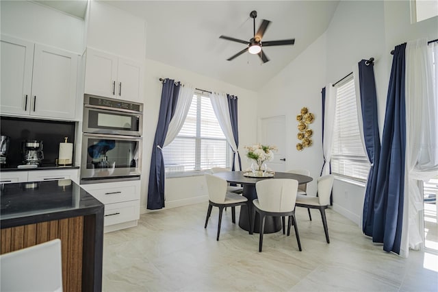 dining area featuring high vaulted ceiling and ceiling fan