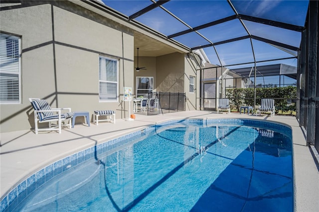 view of swimming pool featuring a lanai, ceiling fan, and a patio