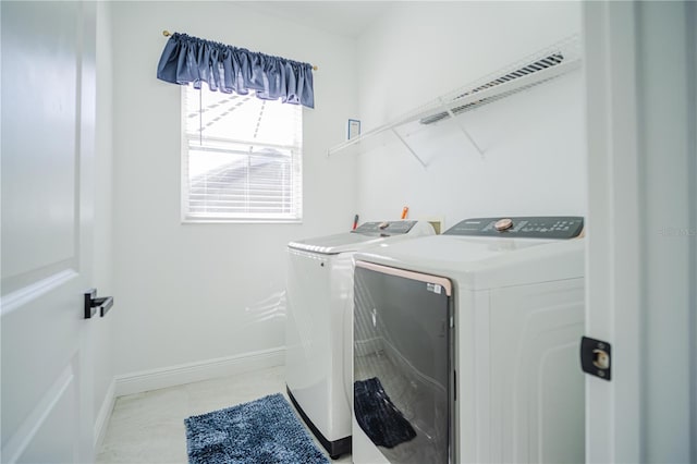 laundry area featuring washing machine and dryer and light tile patterned floors