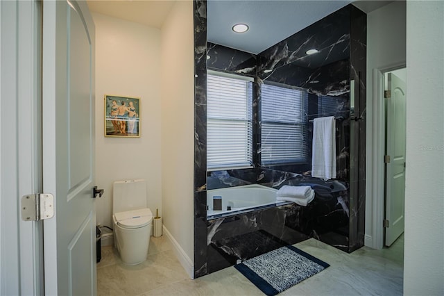 bathroom featuring tiled bath, tile patterned flooring, and toilet