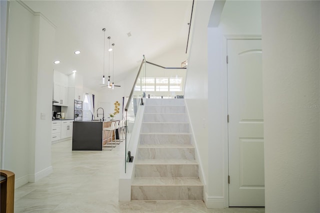 staircase featuring ceiling fan