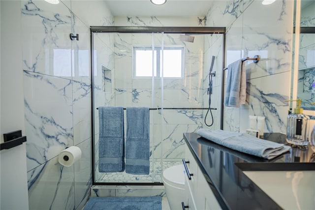 bathroom featuring a shower with door, vanity, tile walls, and toilet