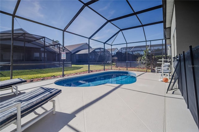 view of swimming pool featuring a lawn, a lanai, and a patio