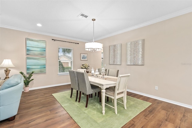 dining area with crown molding and dark wood-type flooring