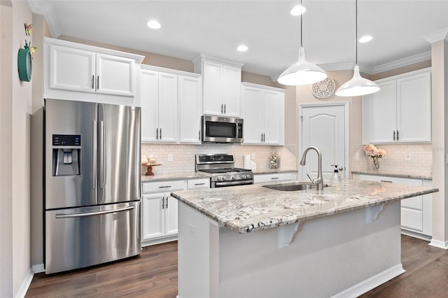 kitchen with white cabinetry, sink, hanging light fixtures, an island with sink, and appliances with stainless steel finishes