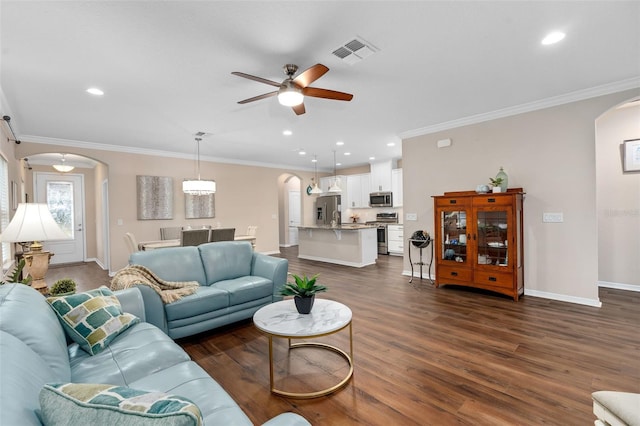 living room featuring dark hardwood / wood-style floors, ceiling fan, and ornamental molding