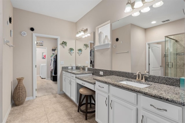 bathroom with tile patterned floors, washer / clothes dryer, vanity, and walk in shower