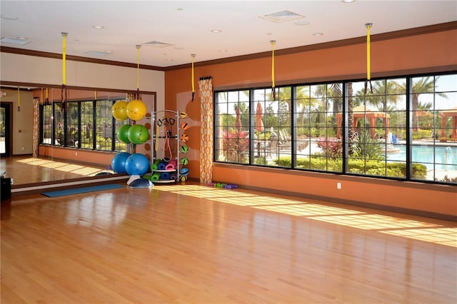 exercise room with basketball court, light hardwood / wood-style flooring, and crown molding