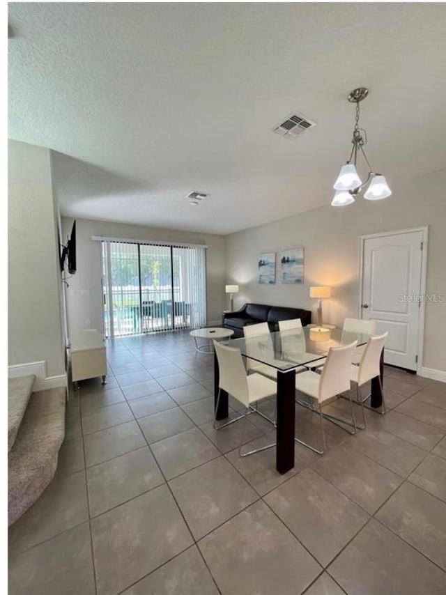 tiled dining room featuring a chandelier