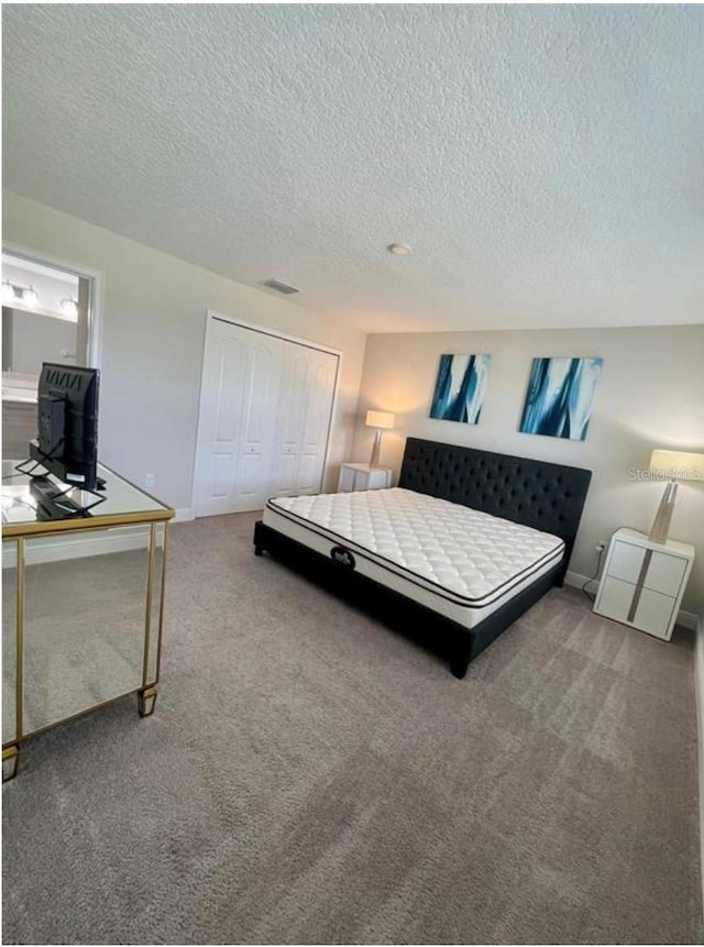 bedroom featuring carpet floors, a closet, and a textured ceiling