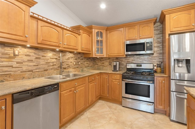 kitchen featuring sink, light stone counters, decorative backsplash, light tile patterned floors, and appliances with stainless steel finishes