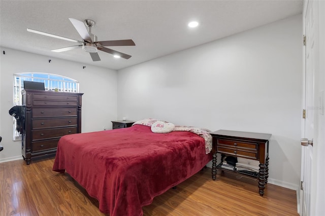 bedroom with ceiling fan and dark hardwood / wood-style floors