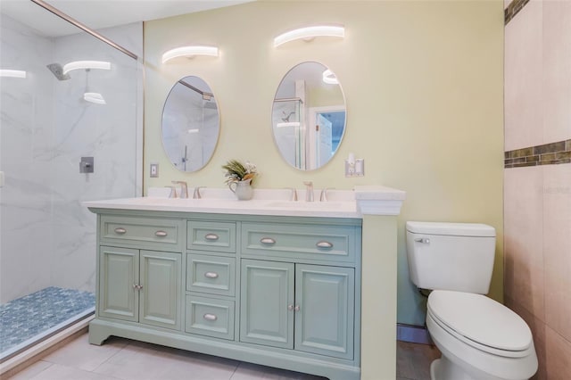 bathroom with tile patterned flooring, vanity, toilet, and tiled shower