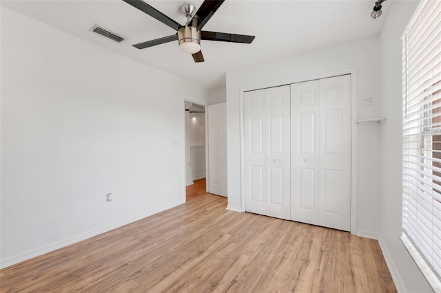 unfurnished bedroom with multiple windows, a closet, ceiling fan, and light hardwood / wood-style floors