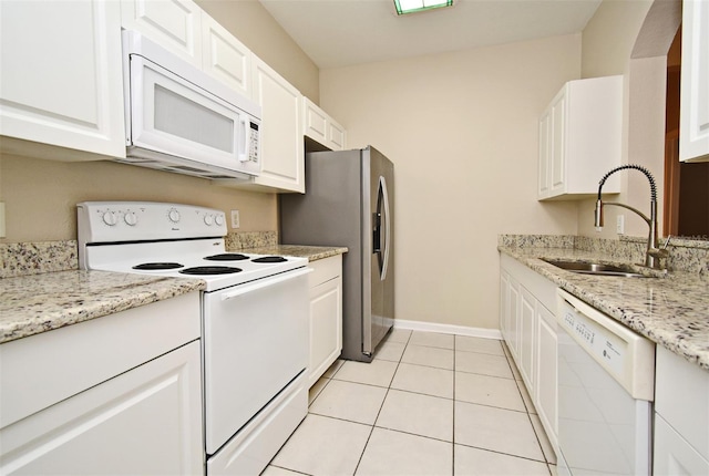 kitchen with white cabinets, white appliances, sink, and light tile patterned floors